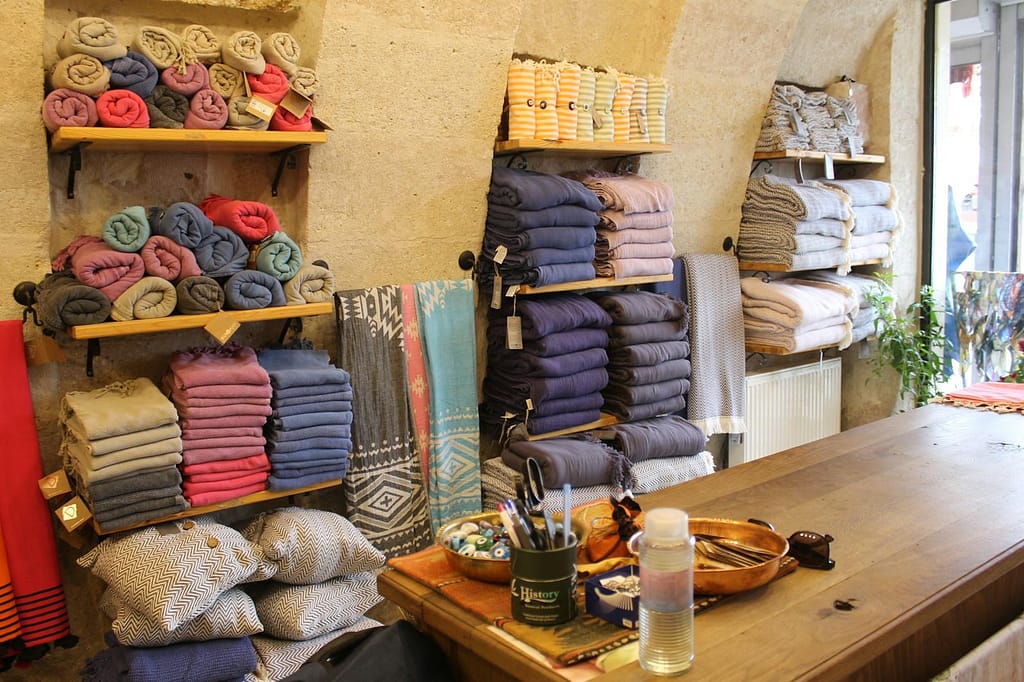 A warm, inviting shop in Göreme with neatly stacked colorful fabrics and textiles ready for sale.