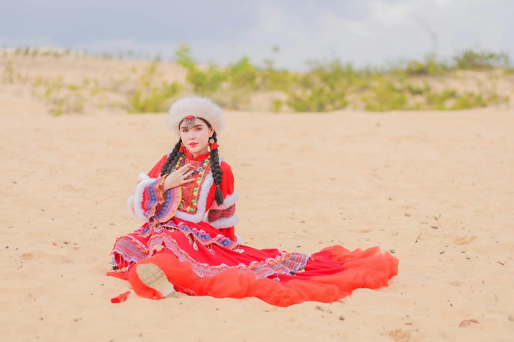 Young Woman Posing in Traditional Mexican Clothes Sitting on a White Sand