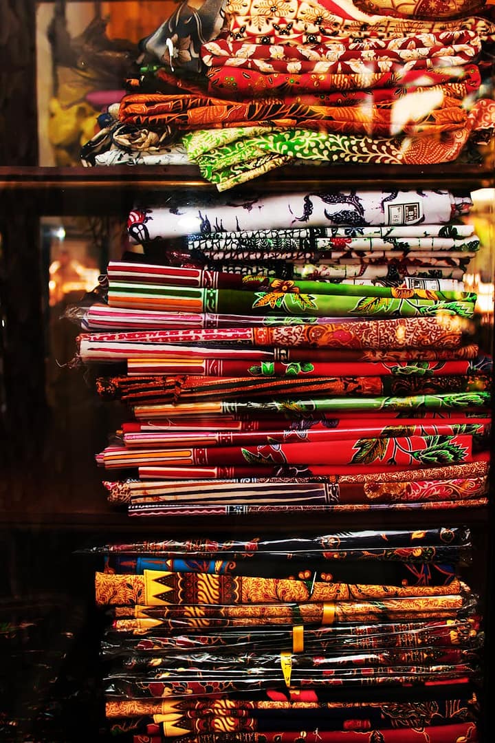 a stack of assorted fabrics on shelves