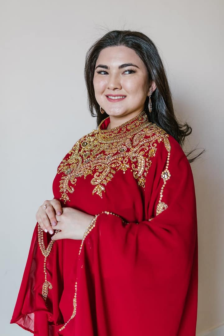 a woman wearing a red kaftan dress