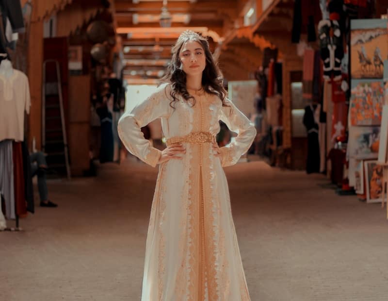 woman in white floral lace long sleeve dress standing on white floor