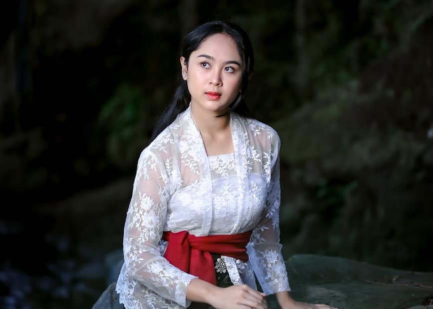 beautiful woman sitting on a boulder