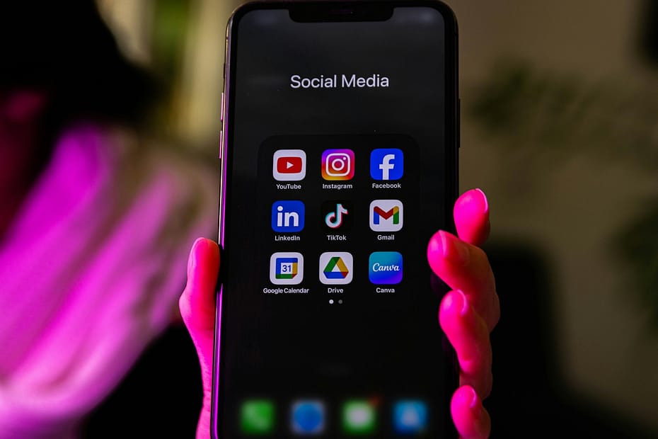 A smartphone displays social media app icons.